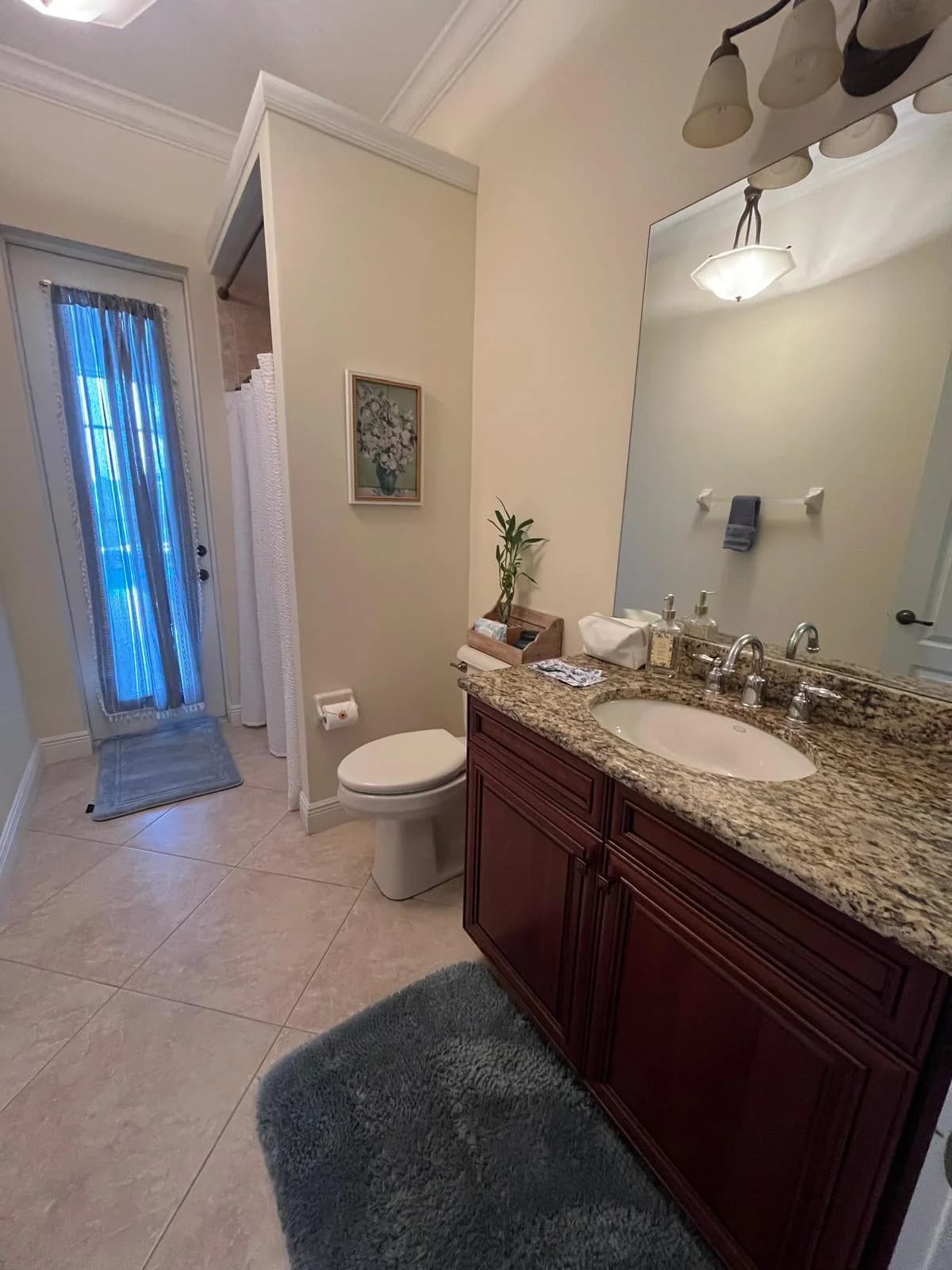 A tidy bathroom hallway with fresh mats and towels.